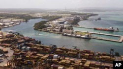 Cargo containers sit stacked as cranes load and unload containers from cargo ships at the Cristobal port, operated by the Panama Ports Company, in Colon, Panama, Feb. 4, 2025.