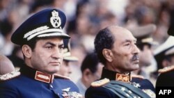 Vitse-prezident Husni Muborak va prezident Anvar Sadat, parad paytida otishma boshlanishidan bir necha daqiqa oldin olingan rasm, 6 oktabr 1981