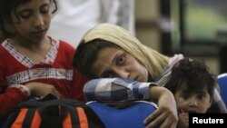 Asylum seekers wait in a police station in Surabaya , East Java province, July 29, 2012. 