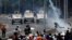Opposition demonstrators face military vehicles near the Generalisimo Francisco de Miranda Airbase "La Carlota" in Caracas, Venezuela, April 30, 2019. 
