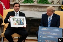 President Donald Trump listens as Gov. Ron DeSantis, R-Fla., talks about the coronavirus response during a meeting in the Oval Office of the White House, April 28, 2020, in Washington.
