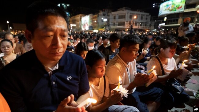 人们在泰国呵叻府参加哀悼死难者的烛光悼念集会。