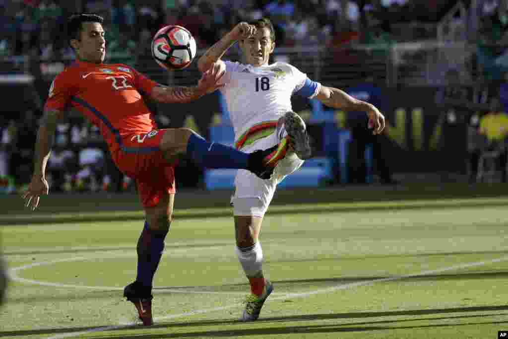 Dan wasan Chile, Edson Puch (hagu) da dan wasan Mexico Andres Guardado su na neman kwallo a karawar ta su.