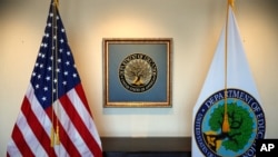 FILE - In this Aug. 9, 2017, photo, flags decorate a space outside the office of the Education Secretary at the Education Department in Washington.