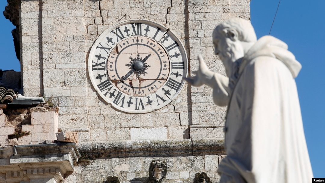 Statua Svetog Benedikta ispred oštećene zgrade gradske skupštine u Norči