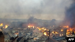 Les ruines en feu du marché de Bouaké le 27 août 2019 suite à un incendie dans la nuit (Photo par - / AFP)