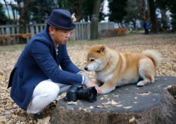File -- Pet owner Shinjiro Ono with his Shiba Inu Maru at Ueno Park in Tokyo.