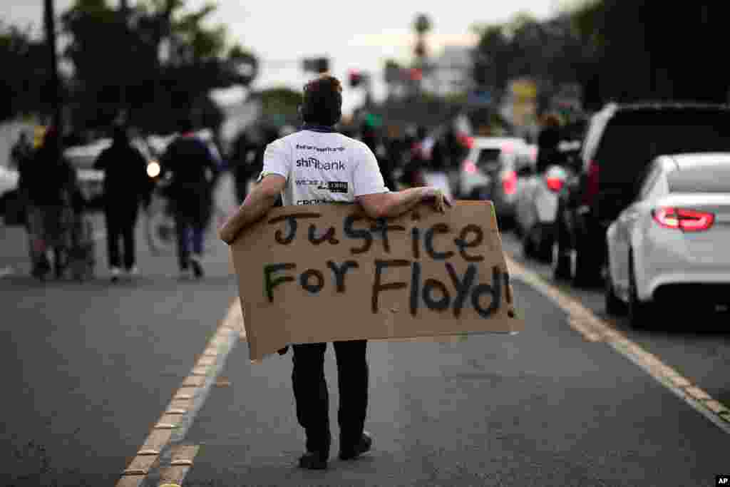 A demonstrator walks with a sign during a protest, June 1, 2020, in Anaheim, California, over the death of George Floyd in Minneapolis.