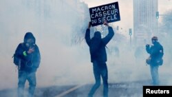 7일 프랑스 파리에서 연금 개혁 반대 시위 6일차 참가자(가운데)가 '마크롱, 세기의 폭도'라는 문구를 들어보이고 있다.
