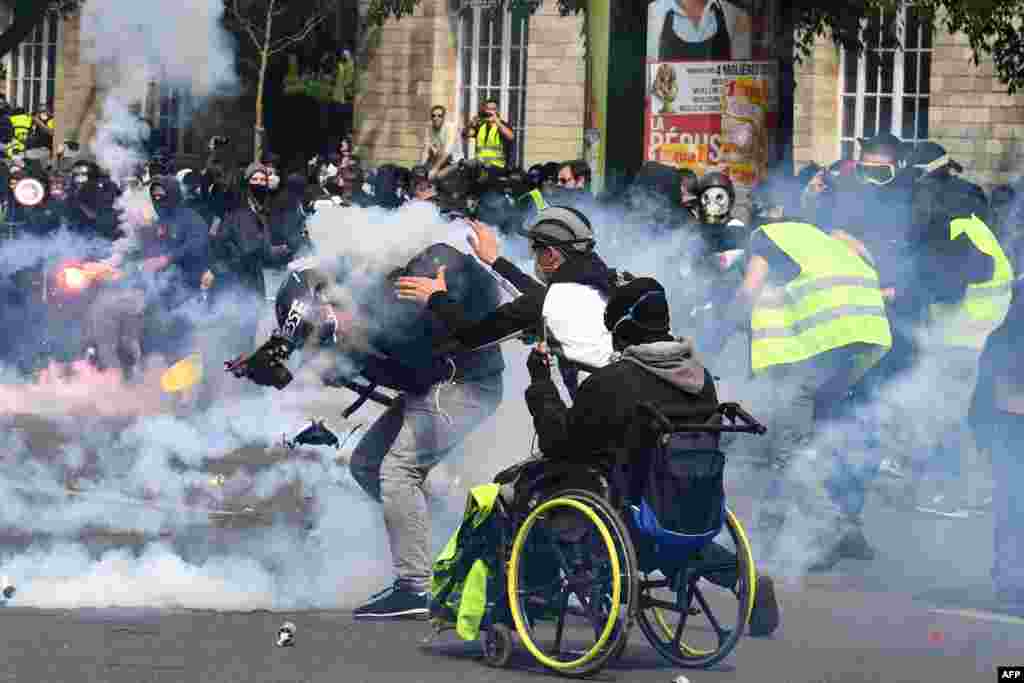 A cameraman is hit by a tear gas canister during clashes with police on the sidelines of the annual May Day rally in Paris, France.