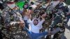 Paramilitary force soldiers detain an activist protesting against Sunday's killing of four farmers in Uttar Pradesh state after being run over by a car owned by India's junior home minister in New Delhi, India, Oct. 4, 2021. 