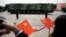 FILE - Onlookers wave Chinese flags as military vehicles carrying DF-41 ballistic missiles roll during a parade in Beijing, China, Oct. 1, 2019.