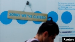 A man walks past a closed branch of the Co-Operative bank following the outbreak of the coronavirus disease in St Helens, Britain, Aug. 12, 2020. 