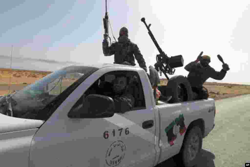 Rebels travel in a convoy on their way to Sirte city near Bin Jawad, March 28, 2011