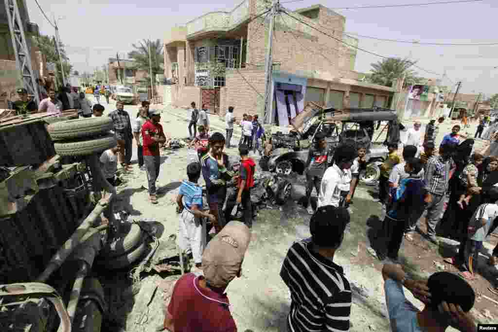 Residents gather at the site of a car bomb attack in Baghdad, April 15, 2013. 