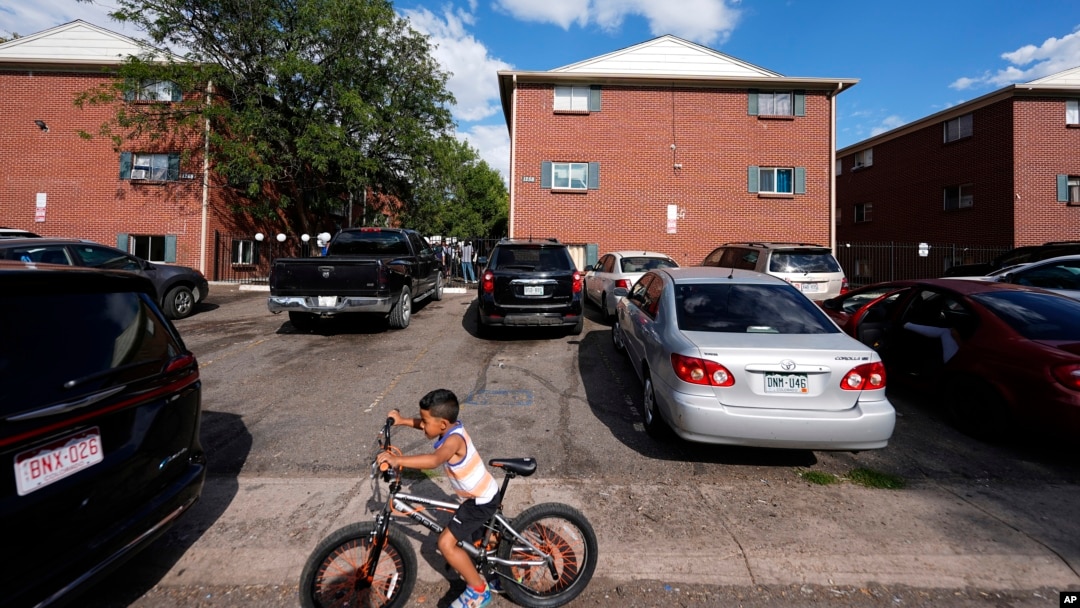 ARCHIVO - Un niño anda en bicicleta durante una marcha organizada por el Colectivo Comunitario de East Colfax para abordar los problemas crónicos en edificios ocupados por personas desplazadas de Centroamérica y Sudamérica, el 3 de septiembre de 2024, en Aurora, Colorado.