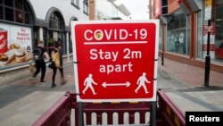 Papan peringatan untuk menjaga jarak sosial di tengah pandemi COVID-19 di Leicester, Inggris, 27 Mei 2021. (REUTERS/Andrew Boyers)