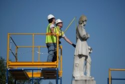 FILE - Houston city workers remove a statue of confederate soldier Dick Dowling from Hermann Park on in Houston, Texas, June 17, 2020.