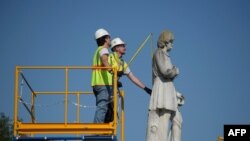 FILE - Houston city workers remove a statue of confederate soldier Dick Dowling from Hermann Park on June 17, 2020 in Houston, Texas.