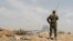 FILE - Soldiers loyal to Syria's President Bashar al-Assad forces are deployed at al-Qadam area near Yarmouk Palestinian camp in Damascus, April 29, 2018.
