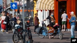 荷蘭阿姆斯特丹，人們在排隊購買傳統的國王節糕點時，一些人戴著口罩，觀察社會距離，以防止冠狀病毒的傳播。 （2020年4月27日）