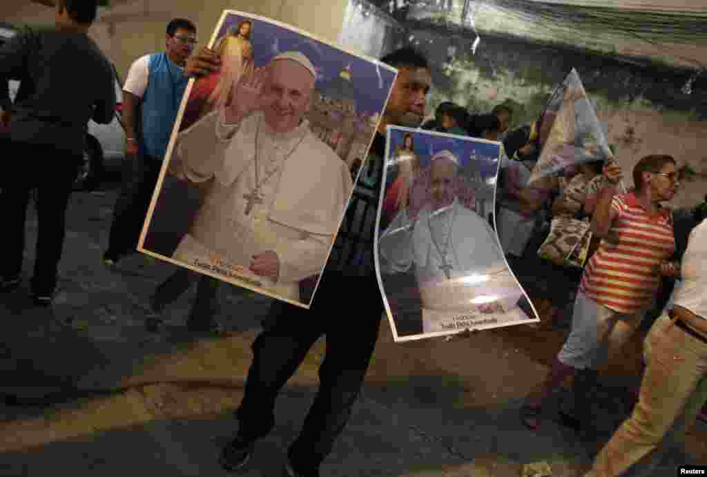 A man sells posters with the Pope's photo during the visit of the World Youth Day cross in the Rocinha slum in Rio de Janeiro, July 18, 2013.