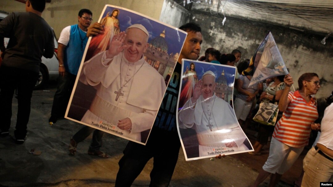 A man sells posters of Pope's visit of World Youth Day cross in Rio de Janeiro, July 18, 2013.