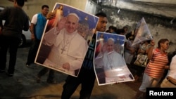 A man sells posters of Pope's visit of World Youth Day cross in Rio de Janeiro, July 18, 2013.