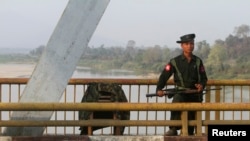 A Myanmar government soldier stands guard on Balaminhtin bridge over the Irrawaddy River near the city of Myitkyina in the north of the country after months of renewed fighting between government troops and the Kachin Independence Army, or KIA, February 2