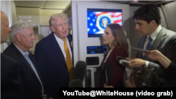 白宫公布的视频截图显示特朗普总统在“空军一号”专机上同媒体交谈。(2026年1月4日)