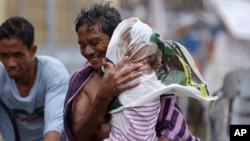 Residents of the slum community of Baseco evacuate to safer grounds at the onslaught of Typhoon Rammasun in Manila, Philippines, July 16, 2014.