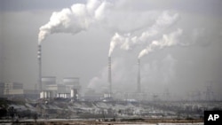 FILE - Smoke billows from chimneys of the cooling towers of a coal-fired power plant in Dadong, Shanxi province, China.