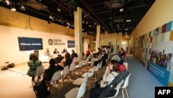 FILE - People attend a conference at the "faith pavilion" at the venue of the COP28 United Nations climate summit in Dubai on December 6, 2023.