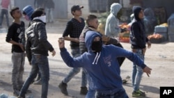 A Palestinian protester throws a stone during a clash with the Israeli military in the West Bank village of Kabatiya, near Jenin, Feb. 5, 2016. 