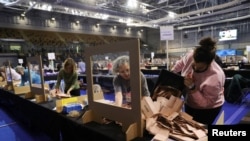Election staff members count votes for the Scottish parliamentary election at a counting center in Glasgow, Scotland, May 8, 2021. 