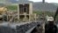 FILE -  A worker at Ashanti Goldfield Company's big mine in Obuasi, Ghana, walks next to a conveyor belt carrying ore up to a processing plant, October 23, 2003.