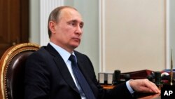 File - Russian President Vladimir Putin listens during a meeting in the Novo Ogaryovo residence, outside Moscow, April 2015.