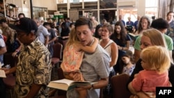 Survivors and churchgoers sing during a Sunday church service held by Pastor Brown of Lahaina's Grace Baptist Church, at Maui Coffee Attic in Wailuku, central Maui, Hawaii on August 13, 2023.