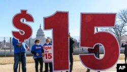 FILE - Activists appeal for a $15 minimum wage near the Capitol in Washington, Feb. 25, 2021.