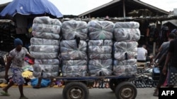 FILE - Traders push a trolley of bales of secondhand clothes at the Kantamanto market in Accra, Ghana, on November 15, 2023.