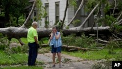 Jackie Jecmenek, a la derecha, habla con Bobby Head, un trabajador de la ciudad, frente a la casa de su vecino tras el paso de Beryl, el lunes 8 de julio de 2024, en Bay City, Texas.