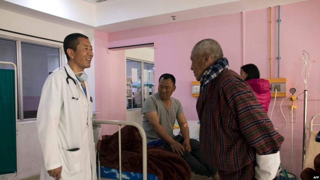 Perdana Menteri Bhutan Lotay Tshering (kiri) berbicara dengan para pasien saat dia memeriksa para pasien di Rumah Sakit Rujukan Nasional di ibu kota Bhutan, Thimpu, 30 Maret 2019. (Foto: AFP)
