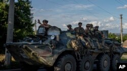 FILE: Ukrainian soldiers ride an armored personnel carrier, on a road in Donetsk region, eastern Ukraine, Wednesday. Taken 7.20.2022