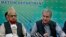Pakistan's Foreign Minister Shah Mahmood Qureshi, right, and top religious leader Mufti Muneebur Rehman, who helped negotiate an end to a protest march by Islamists, give a press conference, in Islamabad, Pakistan, Oct. 31, 2021. 