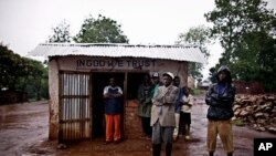 Residents stand outside a shop that was looted by Congolese soldiers during a mass rape and looting campaign in the town of Fizi, Democratic Republic of Congo, February 18, 2011