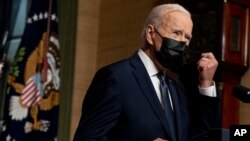 FILE - President Joe Biden removes his mask to speak at a news conference at the White House, in Washington, April 14, 2021. 