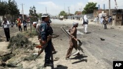 An Afghan man, center, carries the remains of suicide attacker's vehicle in Kabul, Afghanistan, May 31, 2019. 