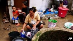The well water these women use to wash clothes is cloudy and brackish. Since piped water is still limited in Penjaringan, they mix it with bleach and keep the clean water for drinking