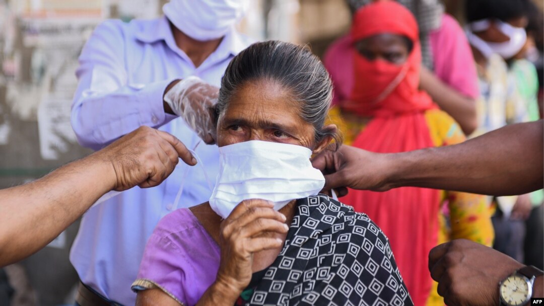 Volunteers from the Diocese of Amritsar Church of North India distribute face masks to people during a government-imposed nationwide lockdown as a preventive measure against COVID-19 in Amritsar on April 15, 2020. 