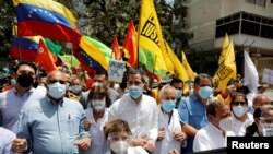 El líder opositor venezolano Juan Guaidó y trabajadores de la salud demandan en una protesta en Caracas el 17 de abril de 2021 que toda la población sea vacunada contra COVID-19.